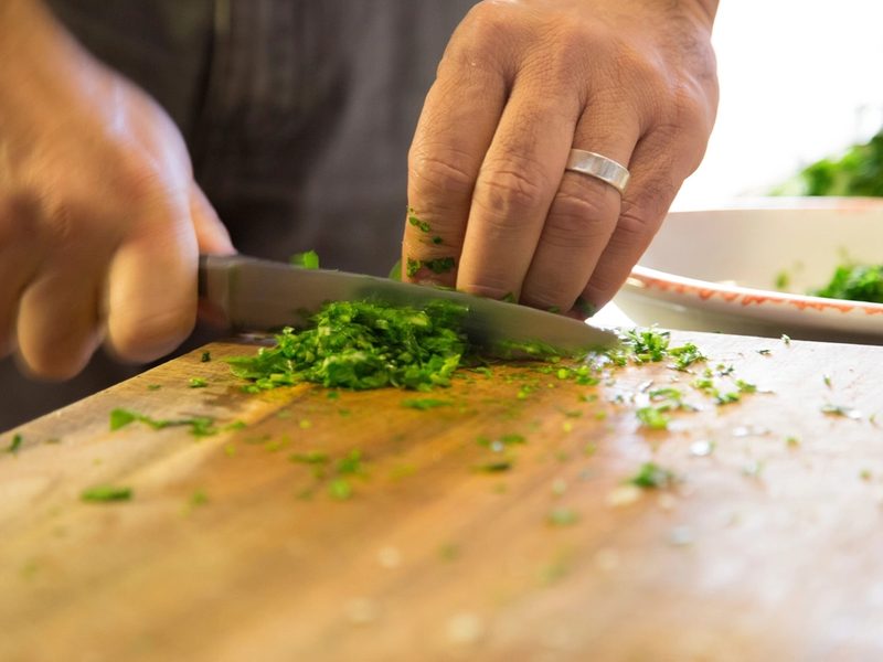 Koch hackt frische Kräuter in der Restaurantküche